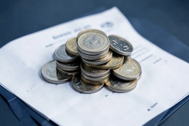 Uma pilha de moedas de dinheiro em cima de um contrato.