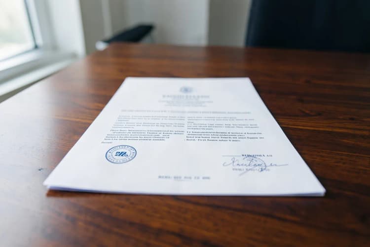 Um documento oficial com selo de cartório e carimbos, sobre uma mesa de madeira.