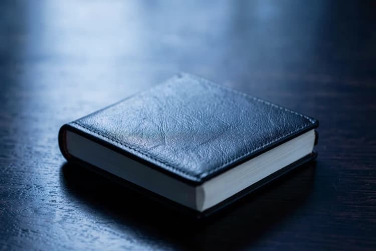 Um livro de capa dura fechado sobre uma mesa de madeira escura, representando a necessidade de consulta jurídica.